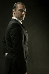 Image showing The attractive man in black suit on dark background