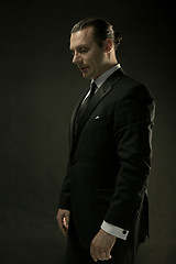 Image showing The attractive man in black suit on dark background