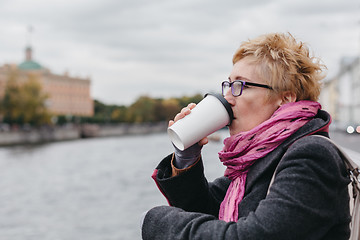 Image showing Woman drinking coffee on waterfront