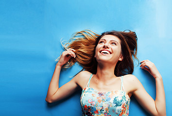 Image showing young pretty woman fooling around on blue background