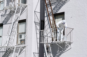 Image showing Building painter painting metal fire escapes white