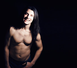 Image showing handsome young man with long hair naked torso on black background