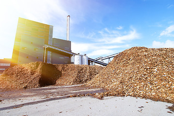 Image showing bio power plant with storage of wooden fuel against blue sky