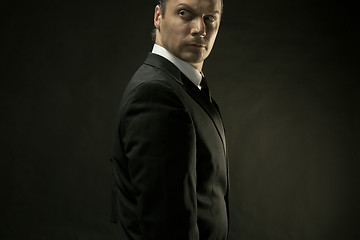 Image showing The attractive man in black suit on dark background