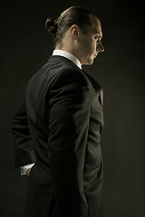 Image showing The attractive man in black suit on dark background