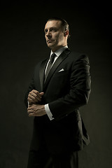 Image showing The attractive man in black suit on dark background