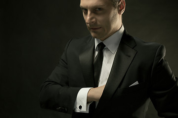 Image showing The attractive man in black suit on dark background