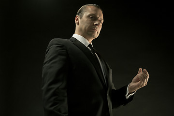 Image showing The attractive man in black suit on dark background