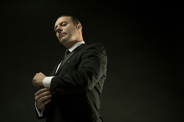 Image showing The attractive man in black suit on dark background