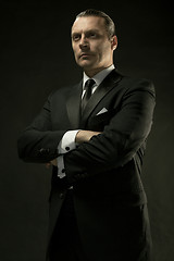 Image showing The attractive man in black suit on dark background