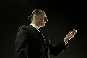 Image showing The attractive man in black suit on dark background