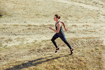 Image showing Running sport. Man runner sprinting outdoor in scenic nature. Fit muscular male athlete training trail running for marathon run.