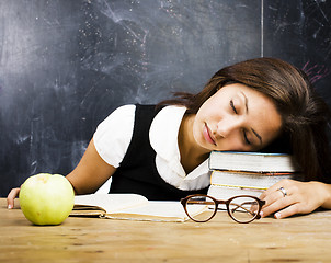 Image showing portrait of happy cute real teen student in classroom at blackboard fall asleep