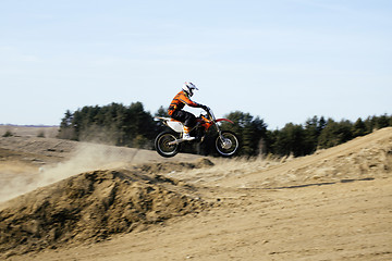 Image showing motorcycle jump from springboard in meadow outside