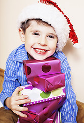 Image showing little cute boy with Christmas gifts at home. close up emotional