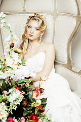 Image showing beauty young bride alone in luxury vintage interior with a lot of flowers close up, bridal style