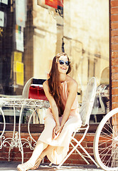 Image showing young pretty brunette woman after shopping sitting at cafe outside on street smiling