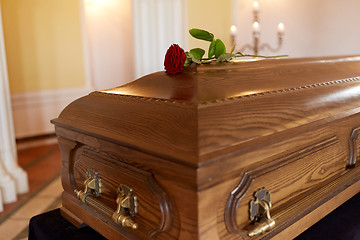 Image showing red rose flower on wooden coffin in church