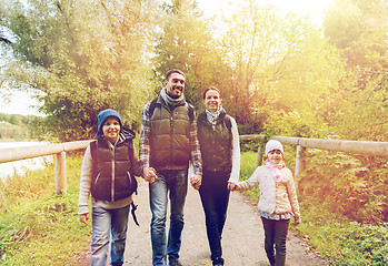 Image showing happy family with backpacks hiking in woods