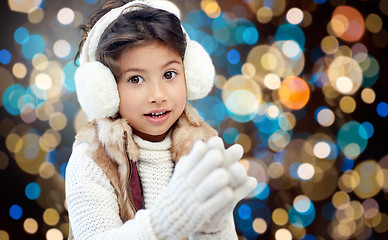 Image showing girl in winter earmuffs over holidays lights