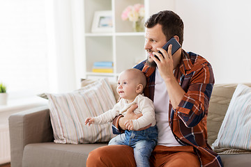 Image showing father with baby calling on smartphone at home