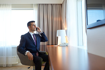 Image showing businessman calling on smartphone at hotel room