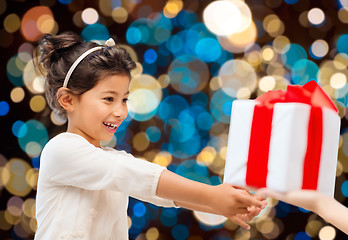 Image showing smiling little girl giving or receiving present