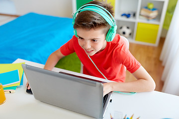 Image showing boy in headphones playing video game on laptop