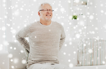 Image showing unhappy senior man suffering from backache at home