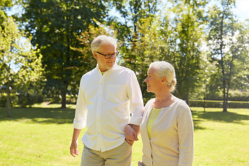 Image showing happy senior couple walking at summer city park