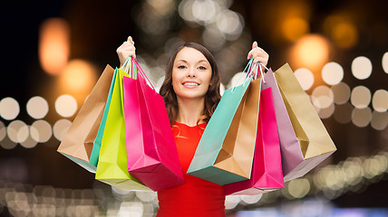Image showing woman in red dress with colorful shopping bags