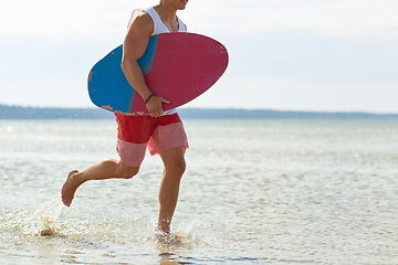 Image showing happy young man with skimboard on summer beach