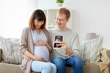 Image showing happy couple with ultrasound images at home