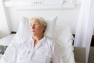 Image showing sad senior woman lying on bed at hospital ward