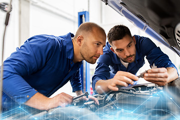 Image showing mechanic men with wrench repairing car at workshop