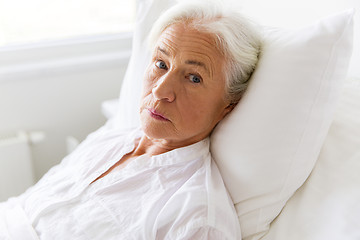 Image showing sad senior woman lying on bed at hospital ward