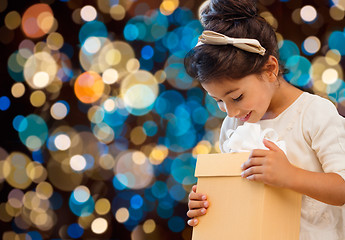 Image showing smiling little girl with gift box over lights