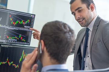 Image showing Stock brokers looking at computer screens, trading online.