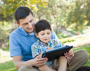 Image showing Happy Father and Son Playing on a Computer Tablet Outside.