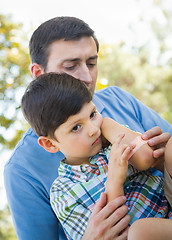 Image showing Loving Father Puts a Bandage on the Elbow of His Young Son in th