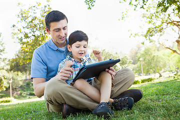 Image showing Happy Father and Son Playing on a Computer Tablet Outside.