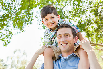 Image showing Mixed Race Father and Son Playing Piggyback Together in the Park