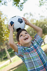 Image showing Cute Young Boy Playing with Soccer Ball Outdoors in the Park.