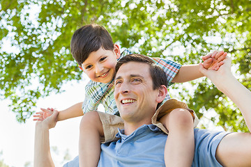 Image showing Mixed Race Father and Son Playing Piggyback Together in the Park