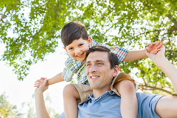 Image showing Mixed Race Father and Son Playing Piggyback Together in the Park