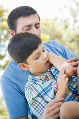 Image showing Loving Father Puts a Bandage on the Elbow of His Young Son in th