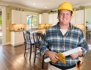 Image showing Contractor With Plans and Hard Hat Inside Custom Kitchen.