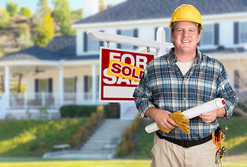 Image showing Contractor With Plans and Hard Hat In Front of Sold For Sale Rea