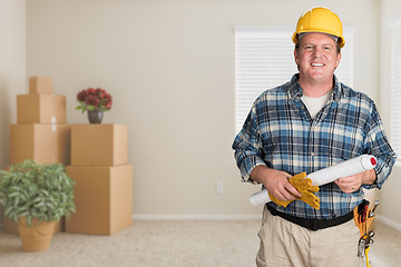 Image showing Contractor With Plans and Hard Hat Inside Empty Room with Moving