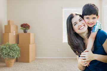 Image showing Young Mother and Son Inside Empty Room with Moving Boxes.